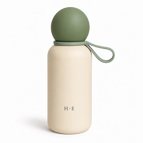 Skog Pebble Bottle: sage-green ball lid with matching green carry loop on cream body, white background
